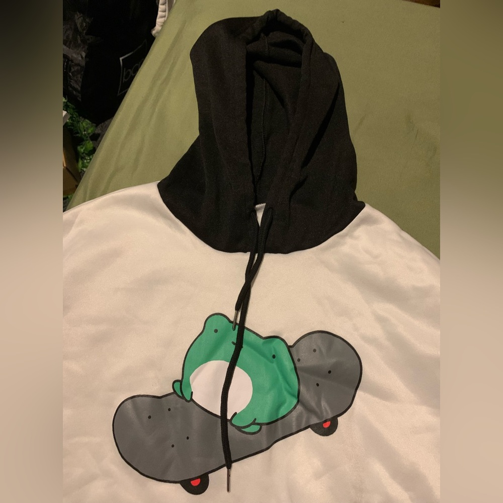 Black and white hoodie. Frog riding skateboard. Black draw strings.